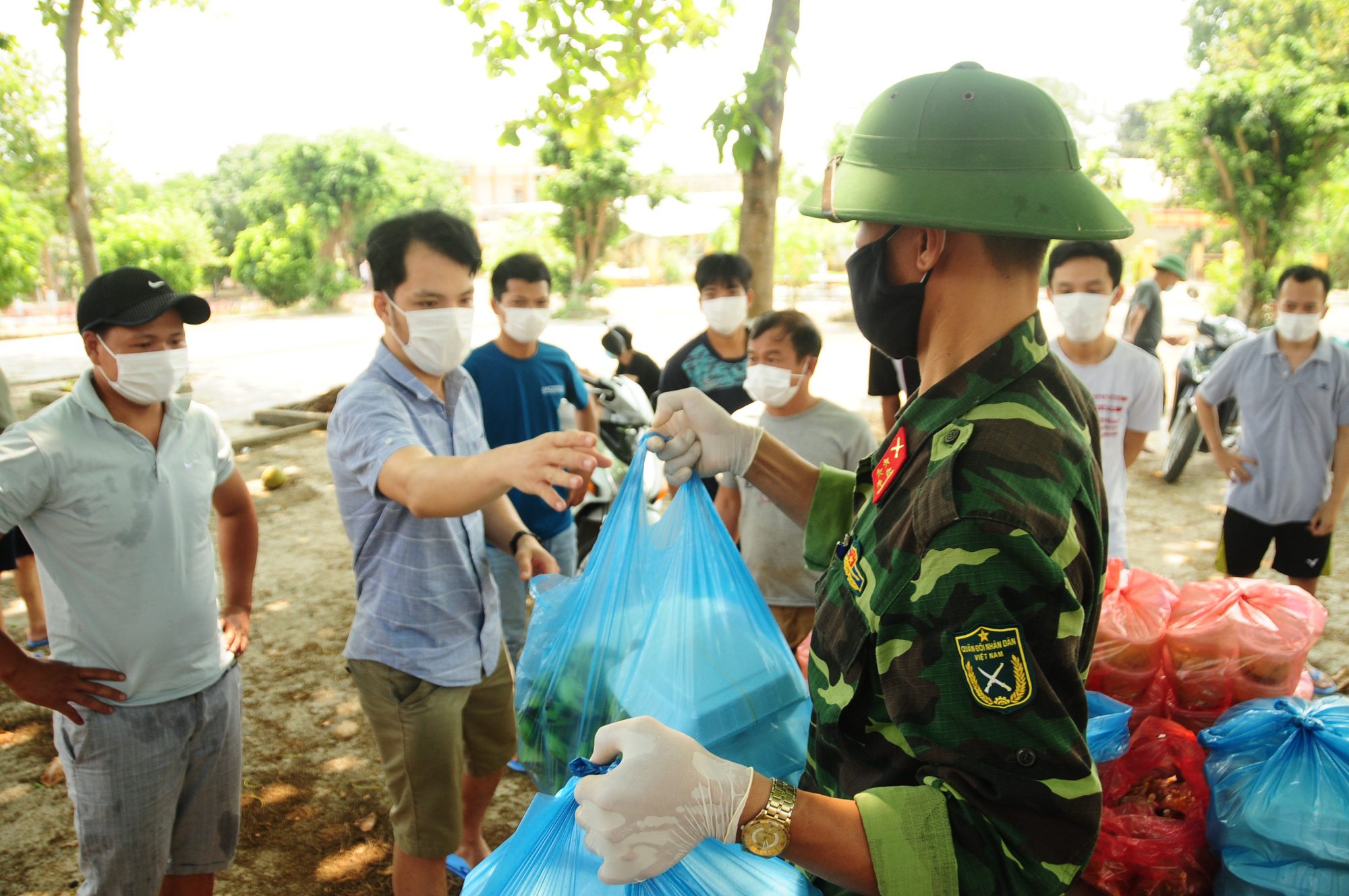 Boxes of steaming rice and food are handed to quarantined people at Hanoi Capital High Command’s Military School in Hanoi, Vietnam. Photo: Nguyen Khanh / Tuoi Tre