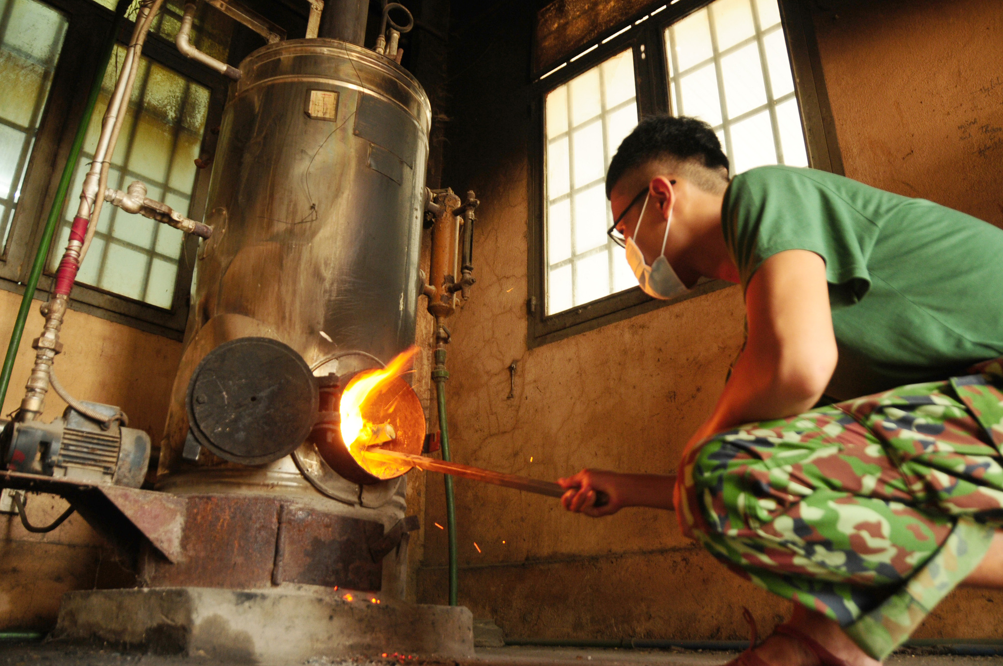 A soldier cooks food in a steamer at a quarantine facility in Vietnam. Photo: Nguyen Khanh / Tuoi Tre