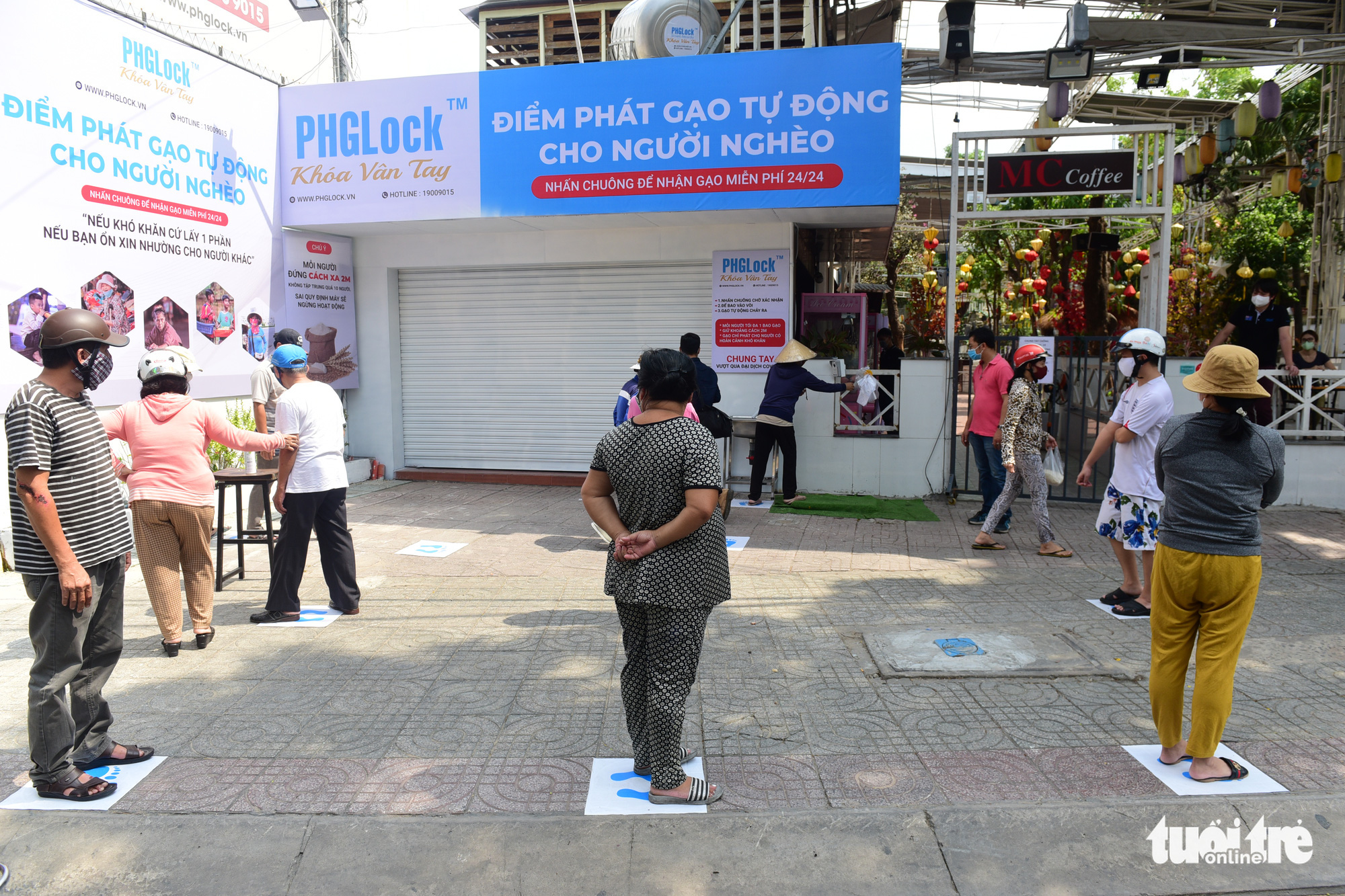 Those who wish to use the 'rice ATM' in Tan Phu District, Ho Chi Minh City, Vietnam must stand on labels placed two meters apart. Photo: Quang Dinh / Tuoi Tre