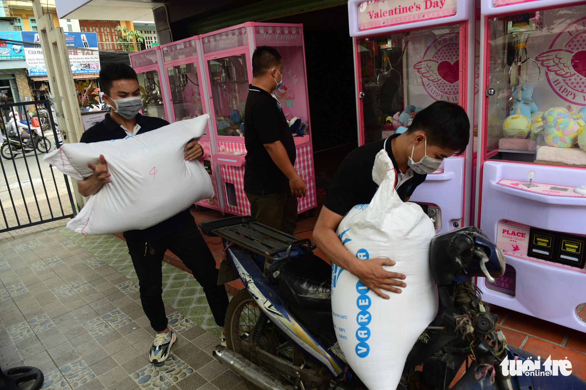 Neighbors donate rice to a 'rice ATM' in Tan Phu District, Ho Chi Minh City, Vietnam. Photo: Quang Dinh / Tuoi Tre