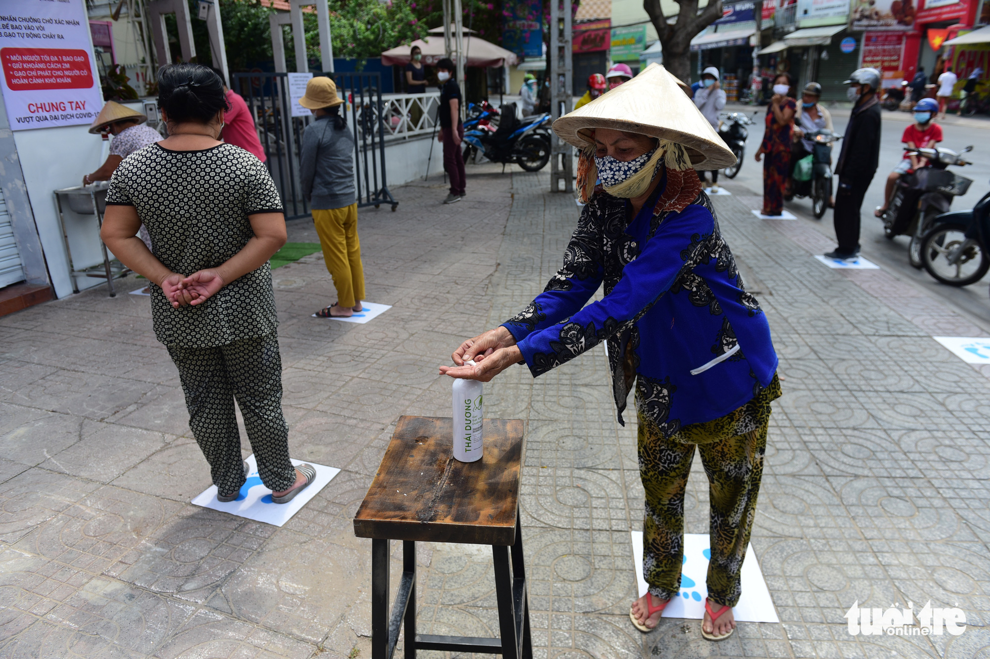 Those in need are asked to wash their hands before making a ‘withdrawal’ from a 'rice ATM' in Tan Phu District, Ho Chi Minh City, Vietnam. Photo: Quang Dinh / Tuoi Tre