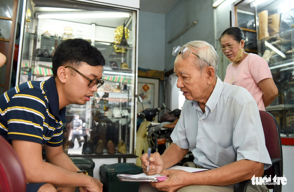 Nham (left), 28, flew from Hanoi to meet Ngoc and order a pair of shoes from the artisan. Photo: Duyen Phan / Tuoi Tre