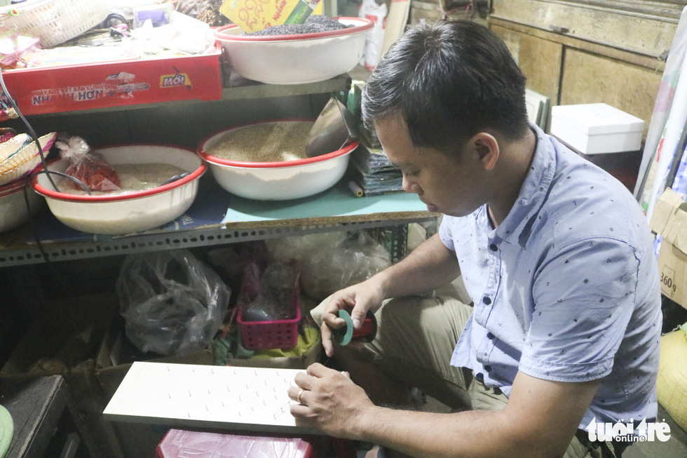 Phan Ba Thanh strings a wire as he is creating a string art. Photo: Thu Hien / Tuoi Tre