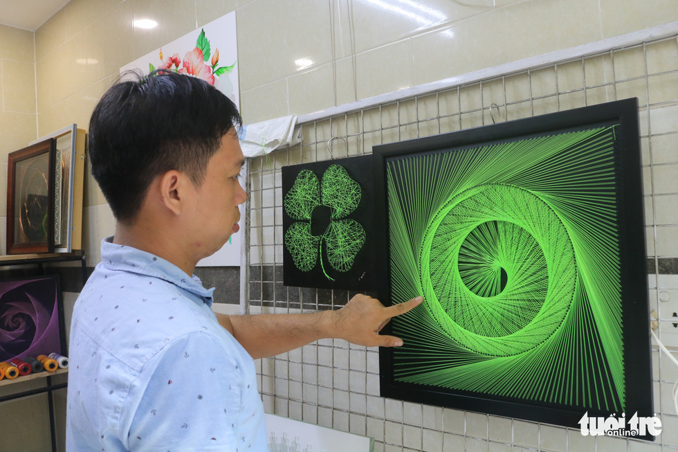 Phan Ba Thanh introduces one of his string arts. Photo: Thu Hien / Tuoi Tre