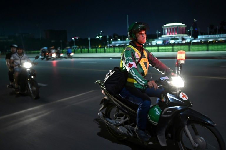 Pham Quoc Viet, who works for ride-hailing firm Grab by day but turns an unofficial emergency responder at night, patrols a street in Hanoi on his motorbike. Photo: AFP