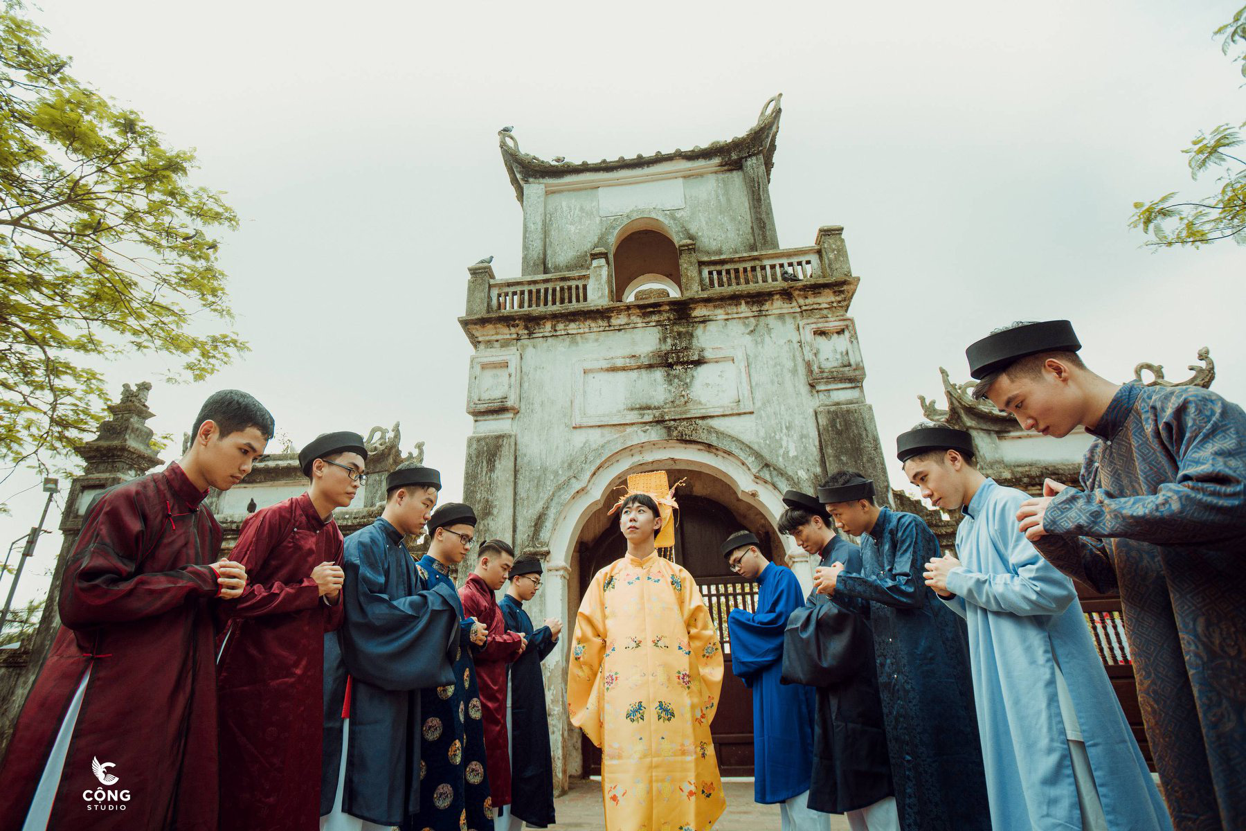 Male students stage a scene with a king, wearing a yellow costume in the middle, surrounded by a few officials in this supplied yearbook photo.