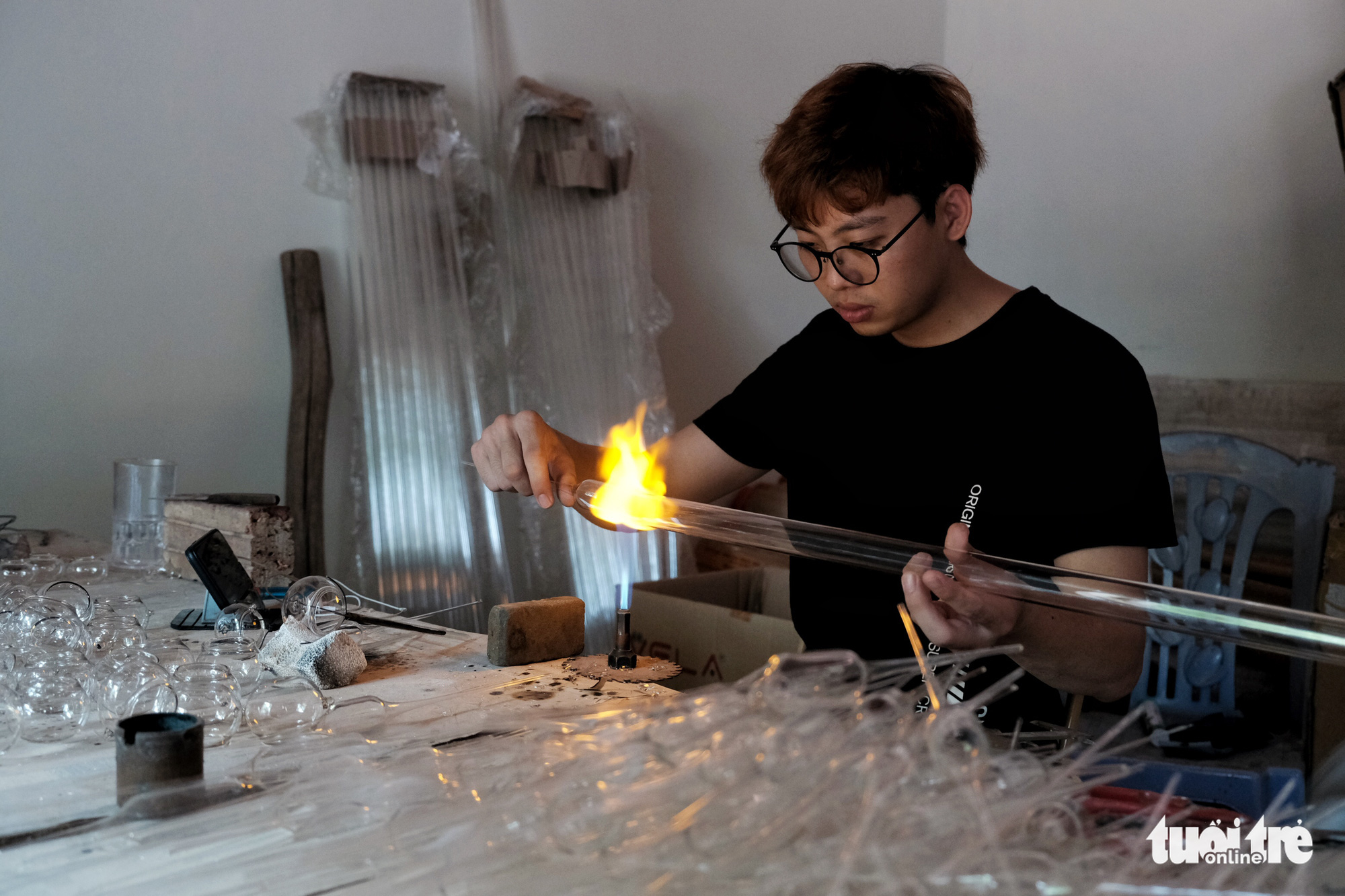 Making products out of glass requires many stages, including one which involves heating a glass tube to create shorter pieces. Photo: Mai Thuong / Tuoi Tre