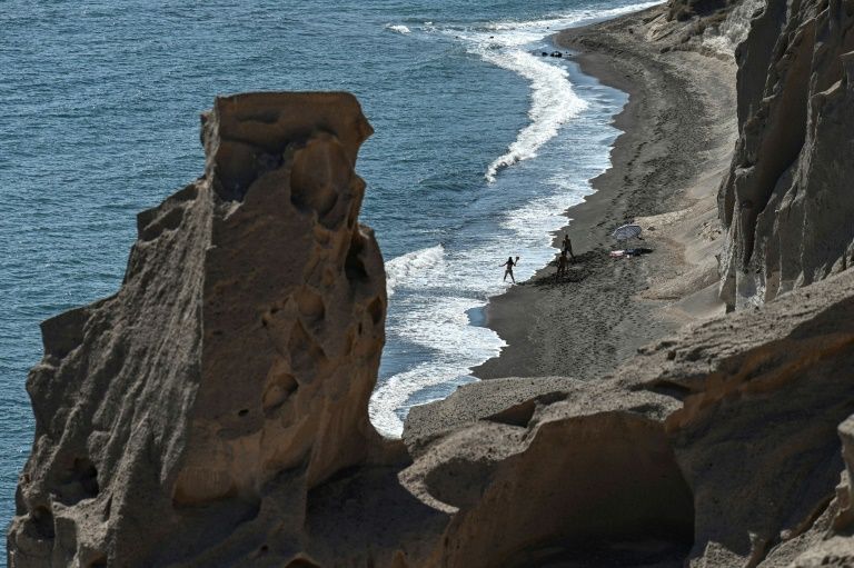 People enjoy the sea and the sun at a beach in the island of Santorini on June 14, 2020 as the country prepares for the return of tourists to Greece from around 30 countries by air, sea and land. Photo: AFP