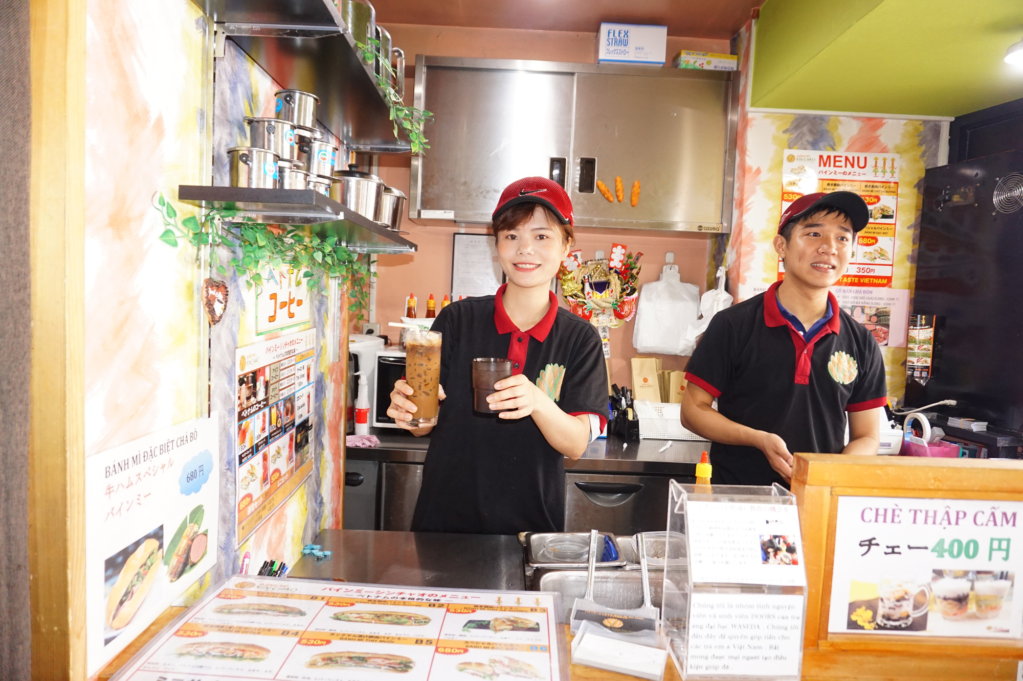 Bui Thanh Tam (right) and his wife stand in a Banh Mi Xin Chao store in Tokyo, Japan. Tam's wife is holding a glass of 'ca phe sua da' (Vietnamese-styled iced coffee with condensed milk). Photo: Cong Nhat / Tuoi Tre
