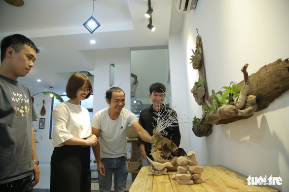 Customers are delighted at embellishing items introduced by Ho Cong Thang (second, right) at his workshop in Hoi An City, Vietnam, where they also learn how to make the products. Photo: Doan Nhan / Tuoi Tre
