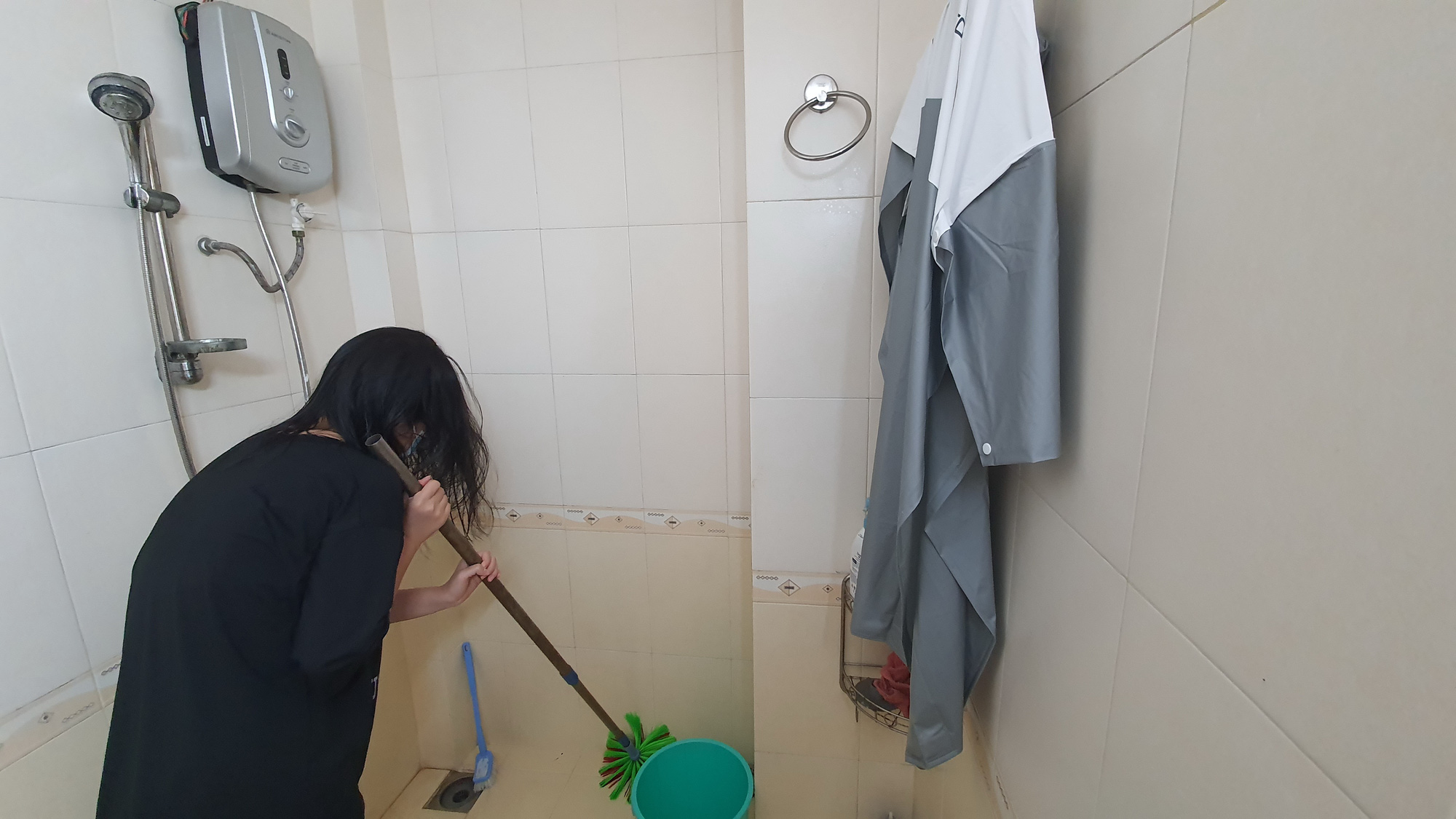 An hourly housekeeper cleans the bathroom of her employer in Ho Chi Minh City, Vietnam. Photo: Le Van / Tuoi Tre