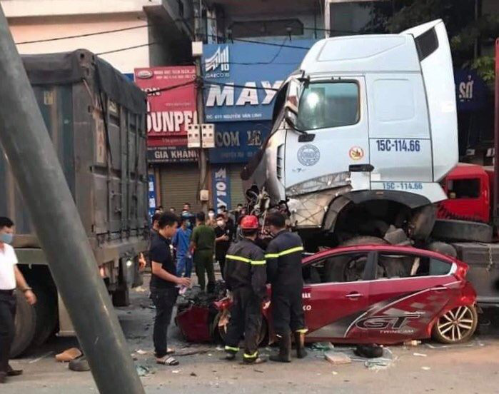 Officers investigate a crash site involving a car and trailer truck in Hanoi, August 4, 2020. Photo: Do Quang / Tuoi Tre
