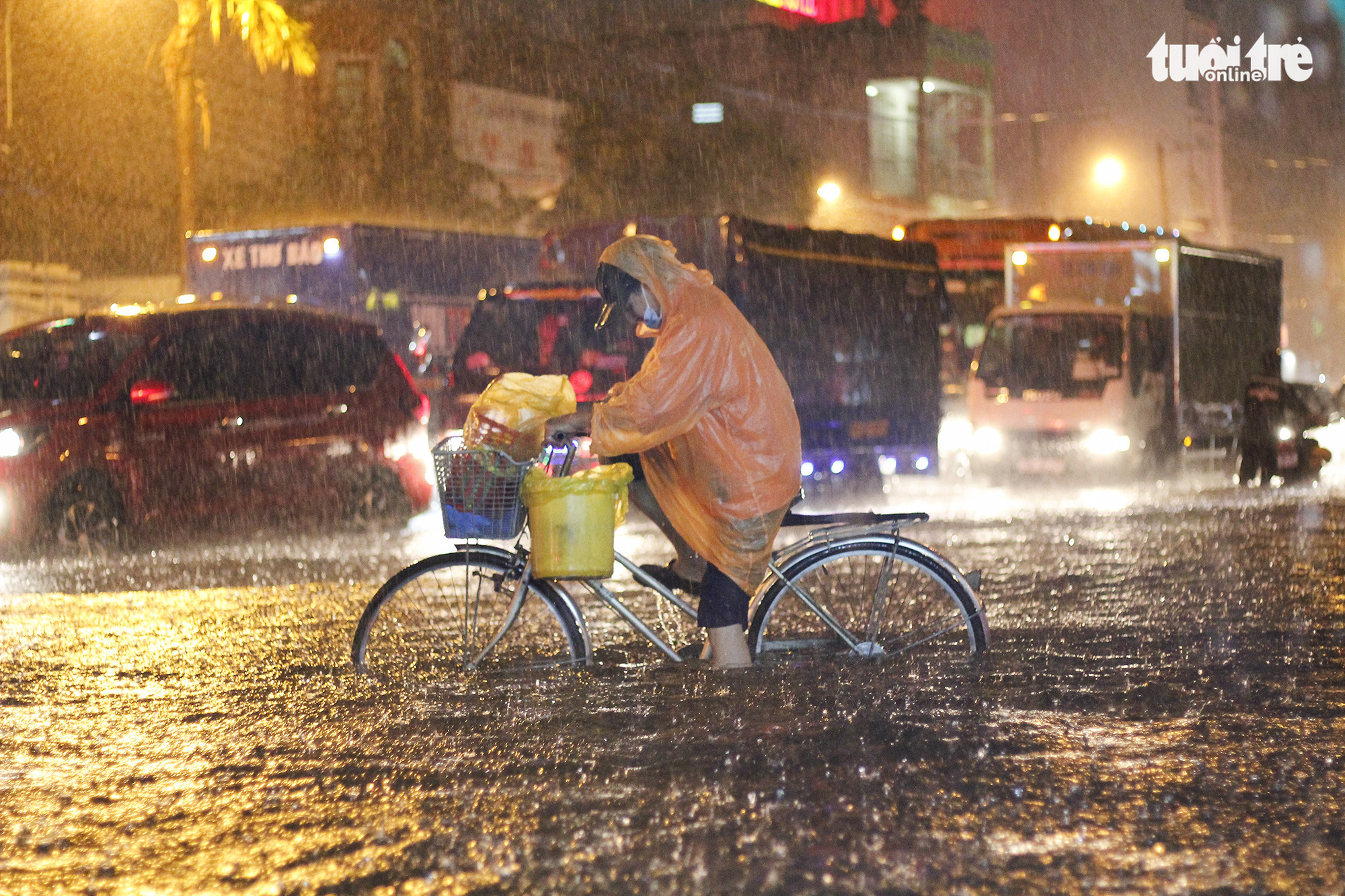 A resident has a hard time riding a bicycle in the heavy downpour that lashed Ho Chi Minh City on August 6, 2020. Photo: Chau Tuan / Tuoi Tre
