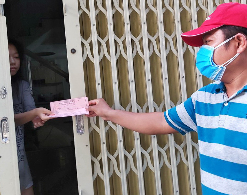 ‘Market access tickets’ are handed to a resident in Da Nang City, Vietnam, August 11, 2020. Photo: D.C. / Tuoi Tre