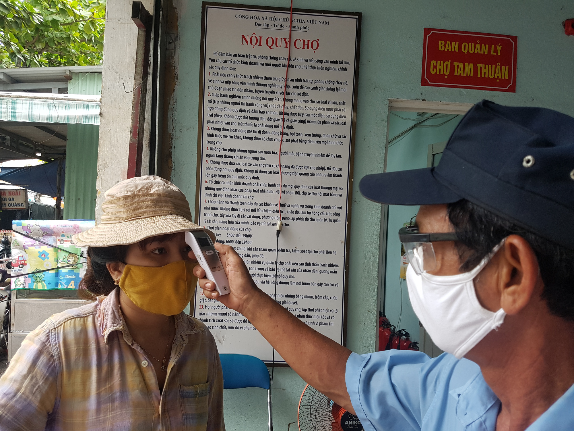 A woman has her body temperature measured before entering a market in Da Nang City, Vietnam, August 12, 2020. Photo: Huu Kha / Tuoi Tre