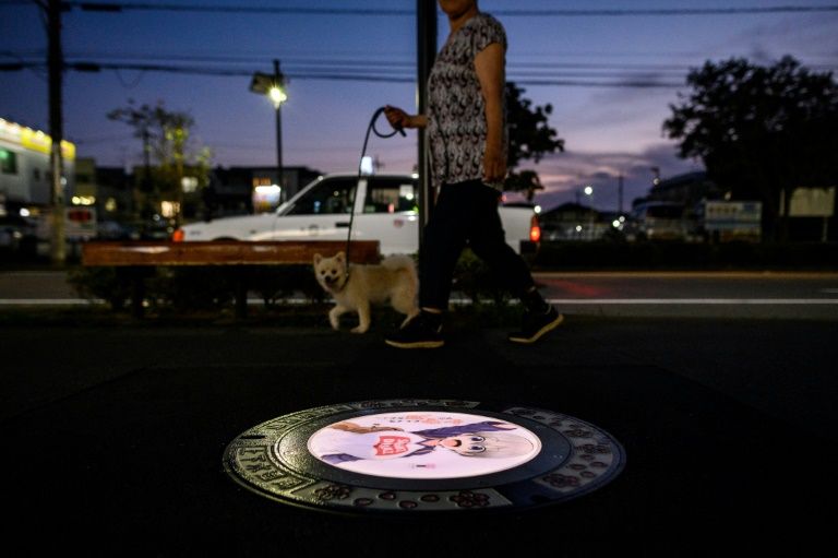 An illuminated manhole cover featuring an anime character in Tokorozawa, Japan. Photo: AFP