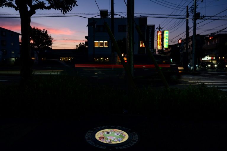 An illuminated manhole cover featuring an anime character in Tokorozawa, Japan. Photo: AFP
