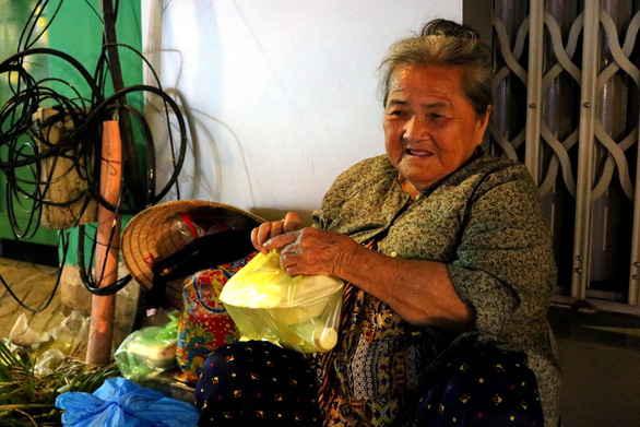 A female scrap dealer receives a free meal and a bottle of water from the group ‘Quyet tam manh’ in Ho Chi Minh City, September 2, 2020. Photo: Hoang An / Tuoi Tre