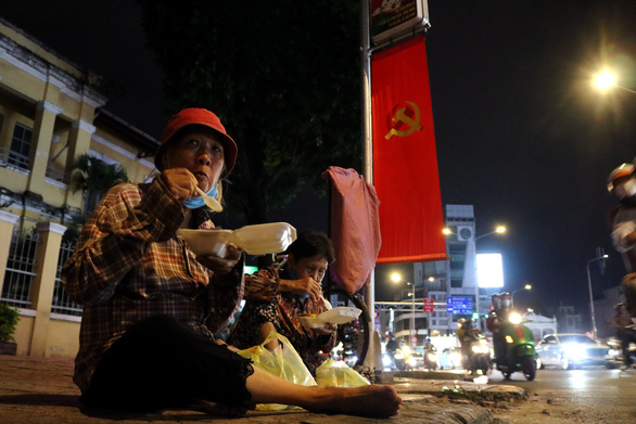 Two female scrap dealers eat free meals given by the group ‘Quyet tam manh’ in Ho Chi Minh City, September 2, 2020. Photo: Hoang An / Tuoi Tre
