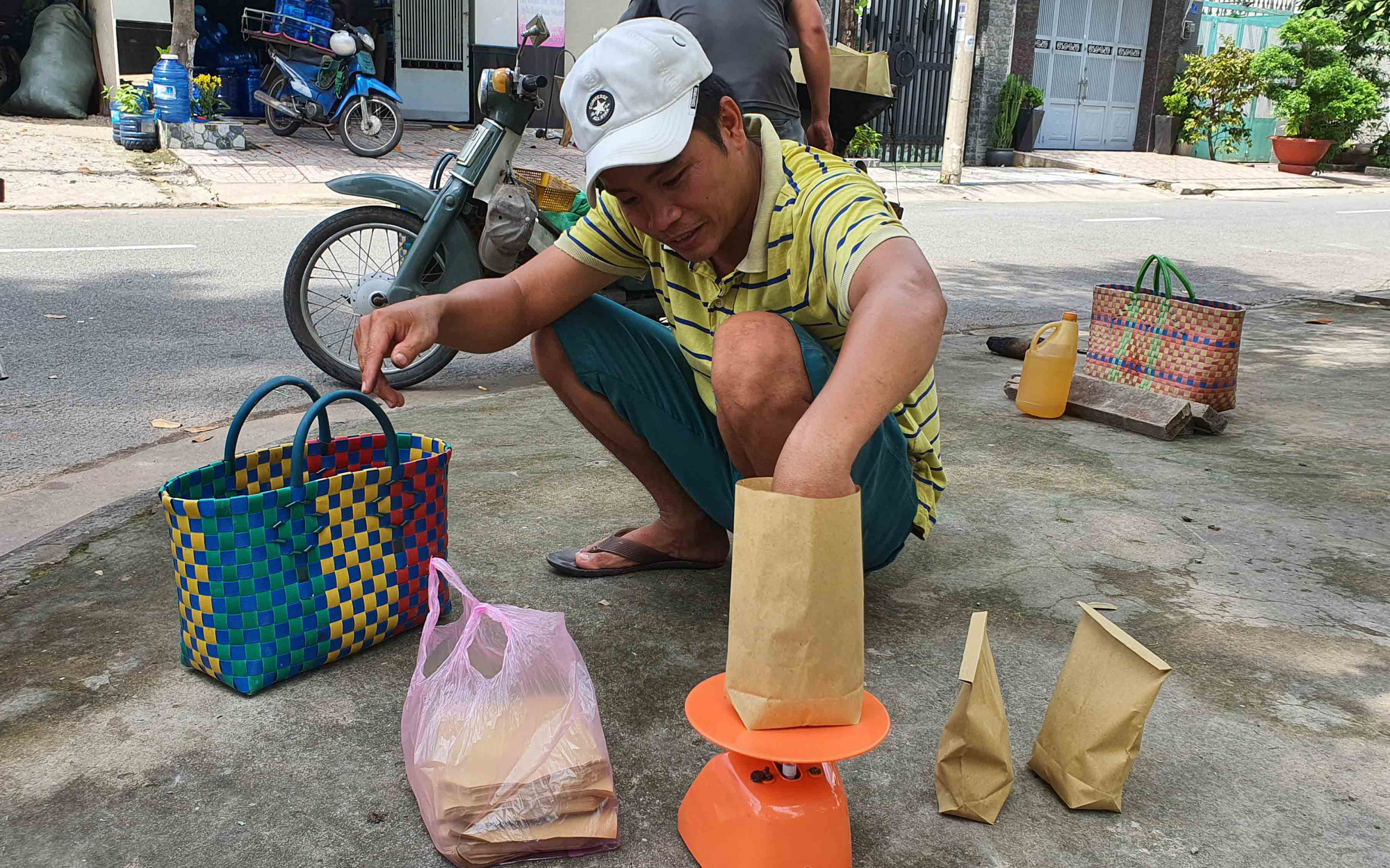 Ngo Dinh Phong, Loi’s nephew, portions roasted hazelnuts into paper bags at their roadside stall in Ho Chi Minh City, Vietnam. Photo: Manh Dung / Tuoi Tre