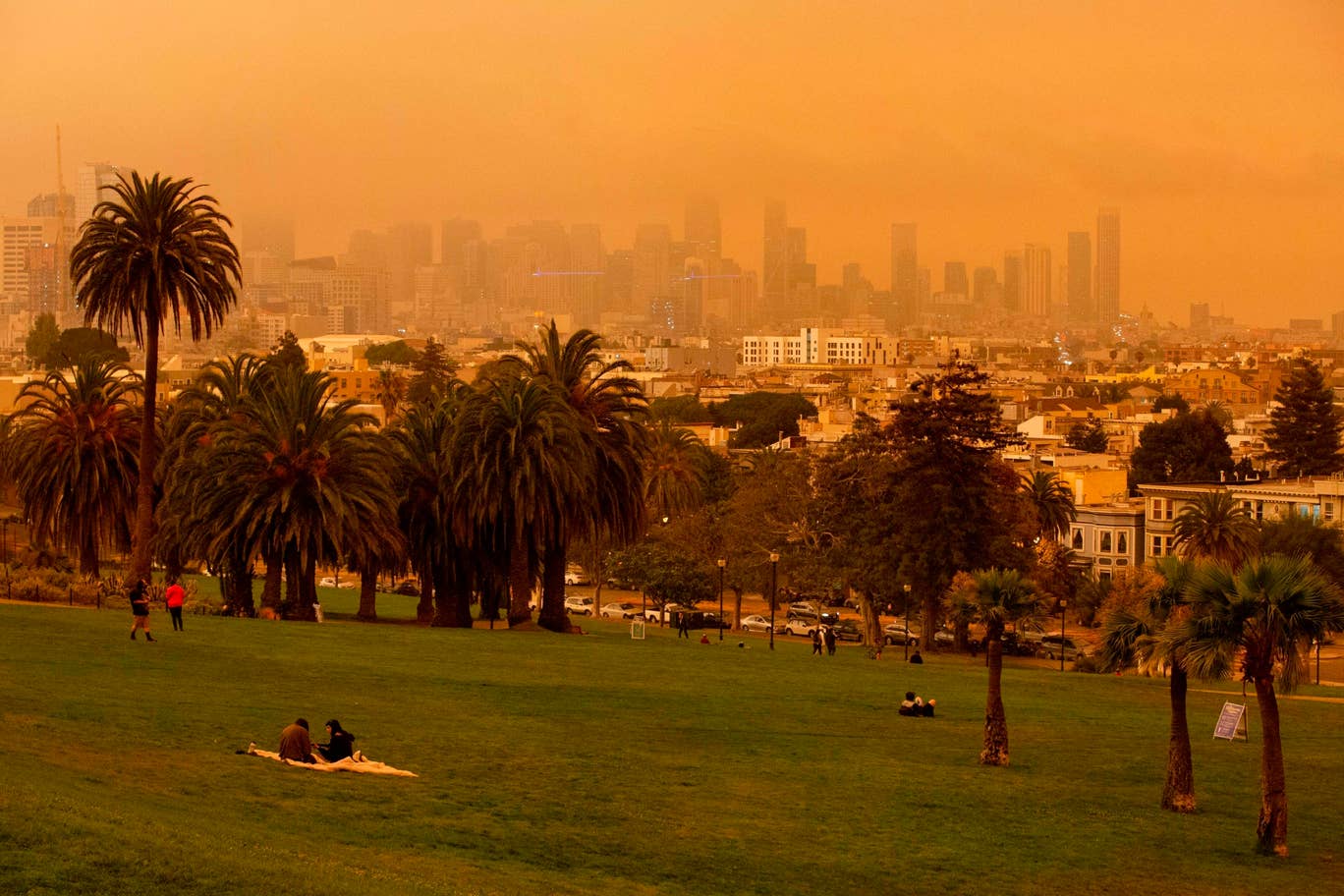 People relax under an orange smoke-filled sky at Dolores Park in San Francisco, California on September 9, 2020. Photo: AFP