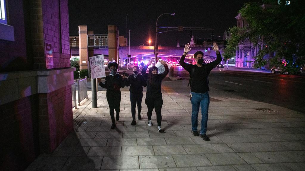 Protestors walk away from police with their hands up after 2 police officers were shot during a protest with police after a grand jury considering the March killing of Breonna Taylor, a Black medical worker, in her home in Louisville, Kentucky, voted to indict one of three white police officers for wanton endangerment, in Louisville, Kentucky, U.S. September 23, 2020. Photo: Reuters