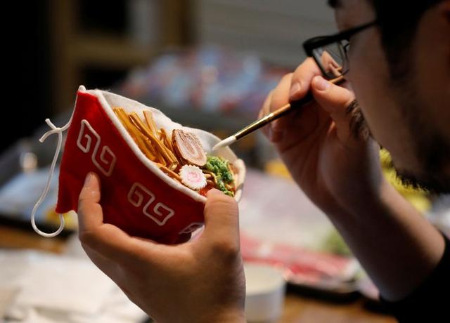 Japanese designer Takahiro Shibata's adds the finishing touches to his protective mask that looks like a steaming bowl of ramen noodle soup, following the coronavirus disease (COVID-19) outbreak, at his house in Yokohama, Japan September 23, 2020. Photo: Reuters