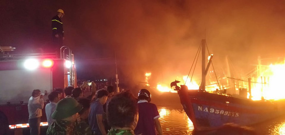 Onlookers watch fishing boats on fire at Lach Quen fishing port, located in Quynh Luu District in Nghe An Province, Vietnam, October 9, 2020. Photo: Ngoc Tuan / Tuoi Tre