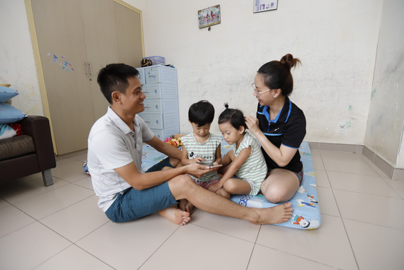 Dao Van Han, a lecturer at the VNU - Ho Chi Minh City, and his wife Dang Thi Tuyet An, a planning and finance officer at the University of Economics and Law in the VNU - Ho Chi Minh City, play with their twin children at a 35-square-meter apartment at the university’s public housing complex. Photo: Nhu Hung / Tuoi Tre