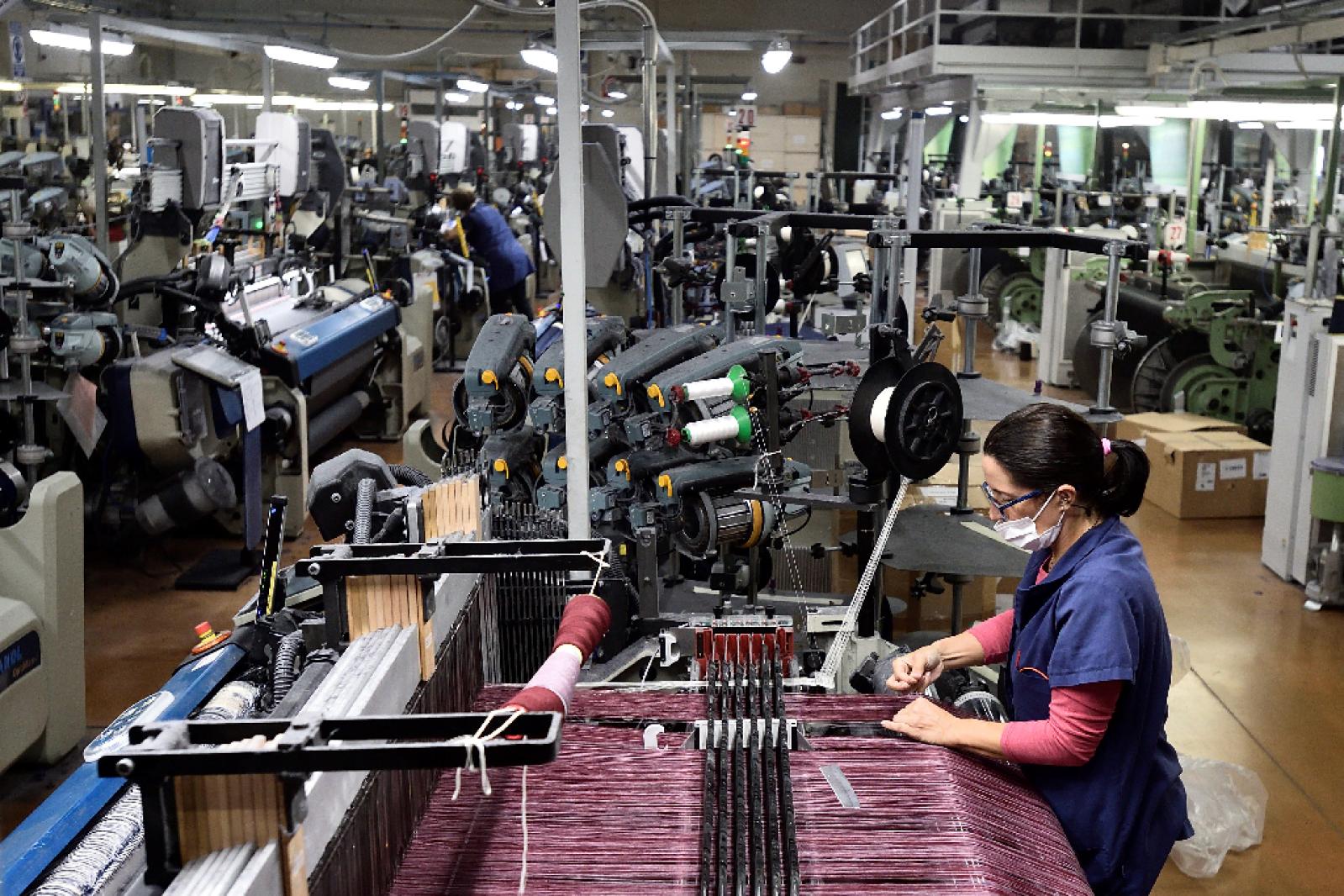 An employee works at Fratelli Piacenza wool mill in Pollone, near Biella, northern Italy, October 8, 2020.  Photo: Reuters