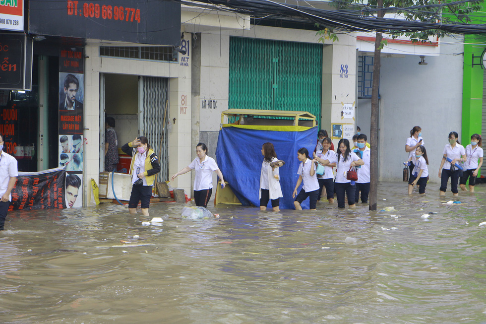 A group of garment workers wade to work in Can Tho City, Vietnam, October 19, 2020. Photo: Chi Cong / Tuoi Tre