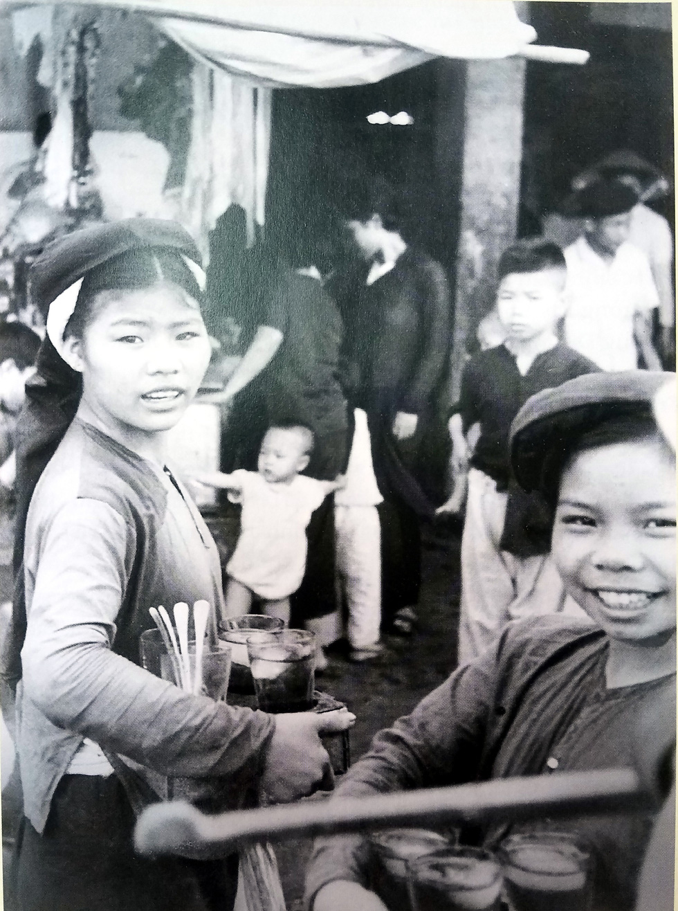 A photo highlights young women peddling pomegranate syrup drinks near Hanoi’s iconic Dong Xuan Market.