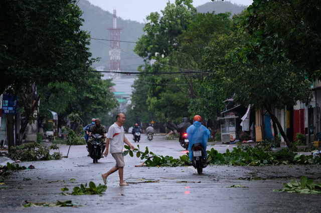 People travel on a street filled with tree branches in Quy Nhon City, Binh Dinh Province, Vietnam, October 28. 2020. Photo: M.Vinh / Tuoi Tre