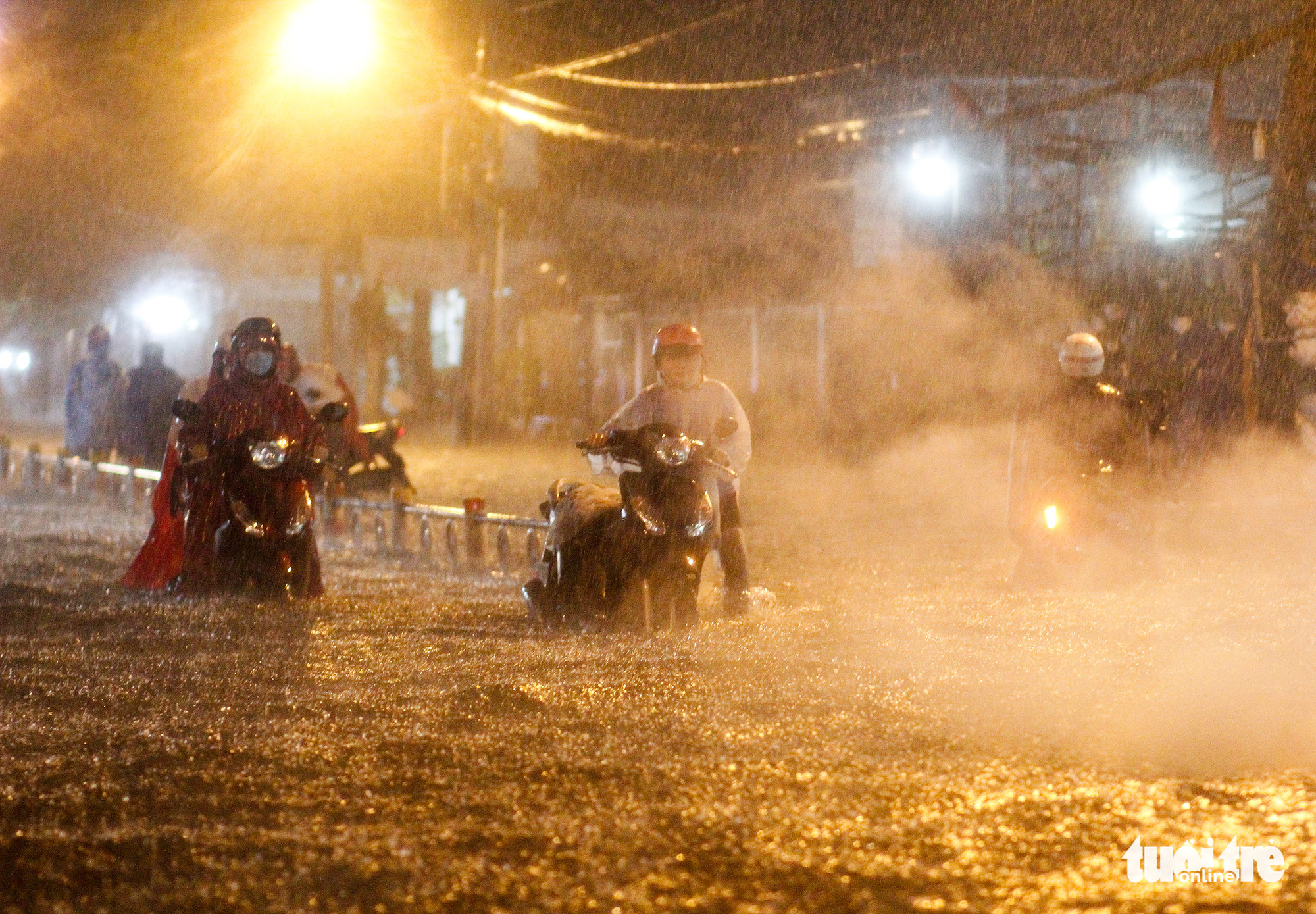 A woman pushes her broken-down motorbike on a flooded street in Ho Chi Minh City, October 31, 2020. Photo: Chau Tuan / Tuoi Tre