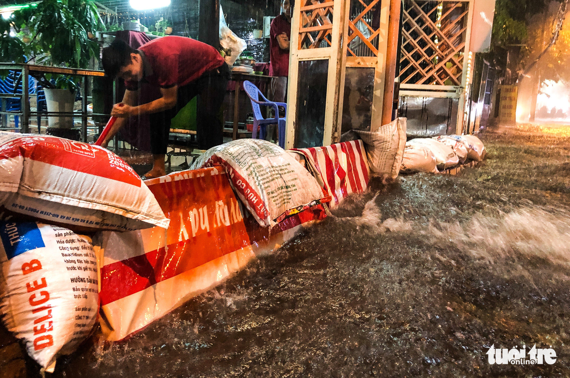 A man uses sandbags to prevent rainwater from pouring into his house in Ho Chi Minh City, October 31, 2020. Photo: Chau Tuan / Tuoi Tre