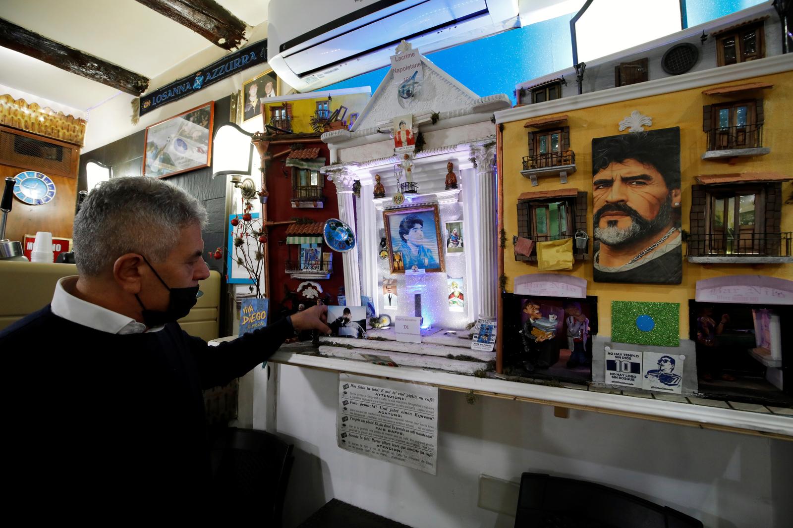 A man wearing a protective face mask holds a picture as he mourns the death of Argentine soccer legend Diego Maradona, in Naples, Italy, November 26, 2020. Photo: Reuters