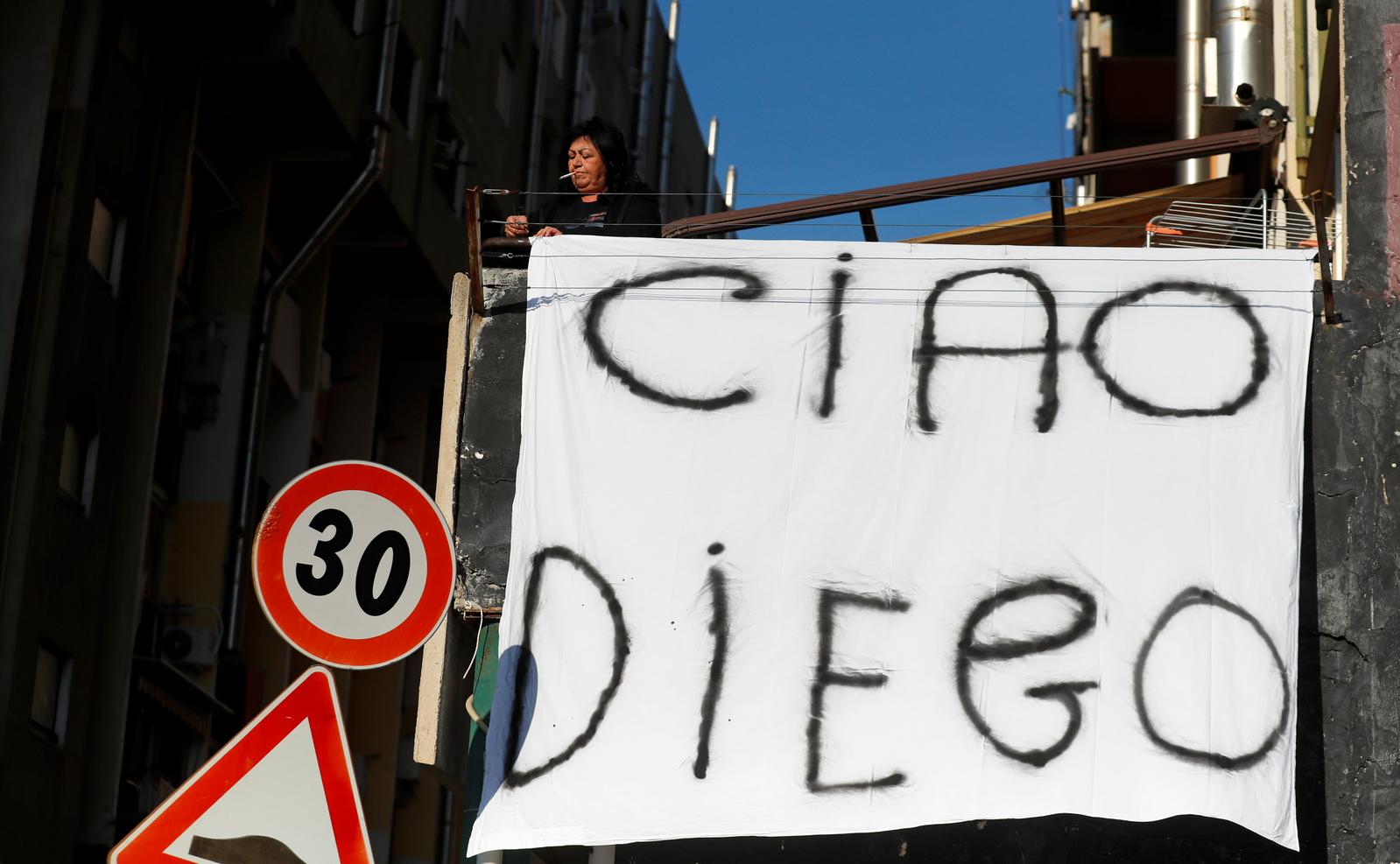A woman hangs out on a balcony a sheet reading 'Bye Diego' to mourn the death of Argentine soccer legend Diego Maradona, in Naples, Italy November 26, 2020. Photo: Reuters