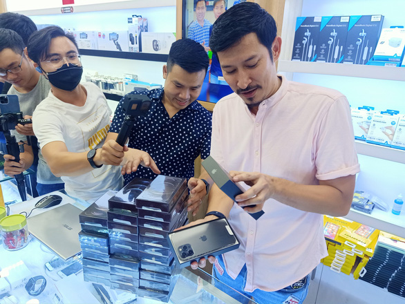 Vietnamese actor Huy Khanh (right) unboxes his new iPhone 12 at Minh Tuan Mobile store in Ho Chi Minh City, November 27, 2020. Photo: Duc Thien / Tuoi Tre