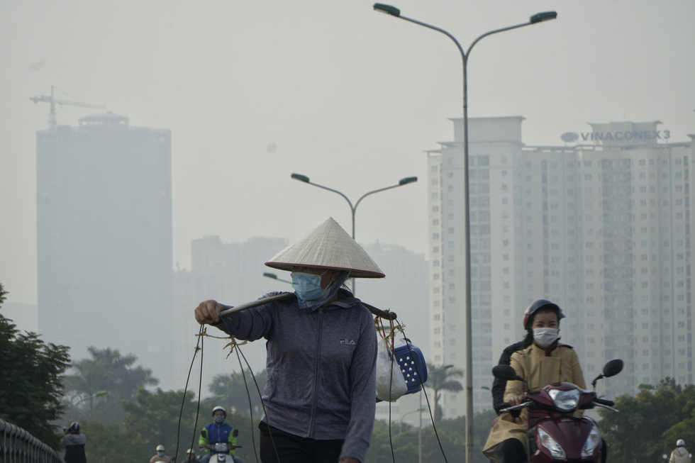 A street vendor is seen through the grey haze in Hanoi. Pham Tuan / Tuoi Tre