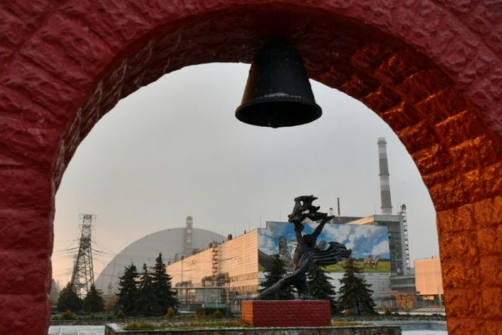 The sarcophagus of the destroyed fourth reactor can be seen behind a monument to the accident -- the 20th anniversary of the plant's final 2000 closure is on Wednesday. Photo: AFP