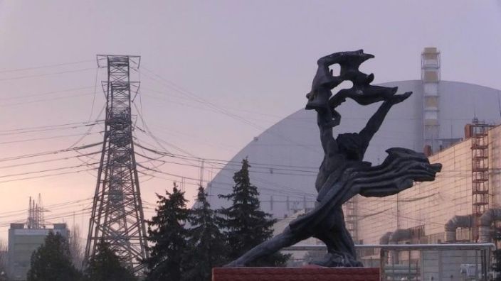 The sarcophagus of the destroyed fourth reactor can be seen behind a monument to the accident -- the 20th anniversary of the plant's final 2000 closure is on Wednesday. Photo: AFP