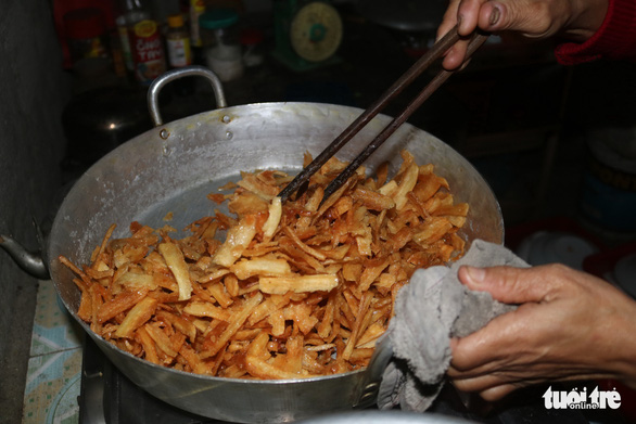 Le Thi Tu sugarcoats pieces of candied cassava in her kitchen in Thua Thien – Hue Province. Photo: Nguyen Trong / Tuoi Tre
