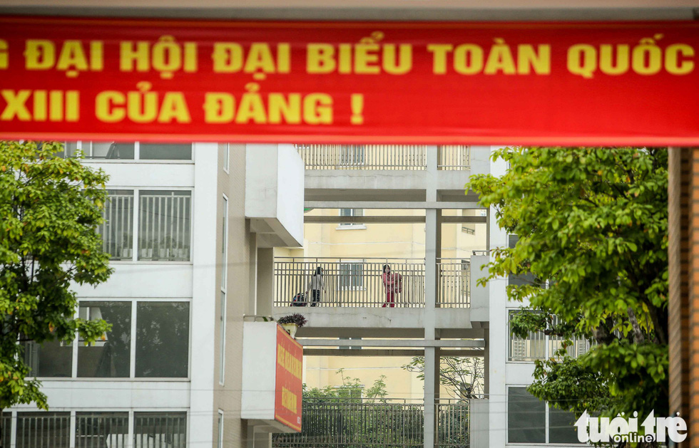Students haul backpacks into Xuan Phuong Primary School for quarantine after one of their schoolmates tested positive for COVID-19, January 31, 2021. Photo: Nguyen Khanh / Tuoi Tre