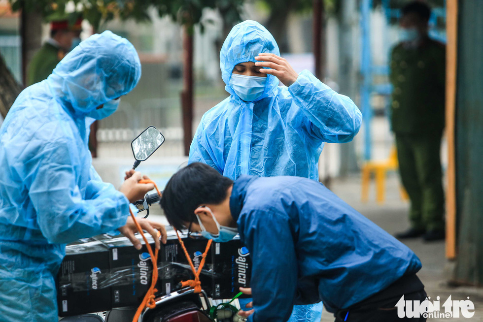 Staffers of the quarantine zone in Xuan Phuong Primary School wear protective overalls and masks, January 31, 2021. Photo: Nguyen Khanh / Tuoi Tre
