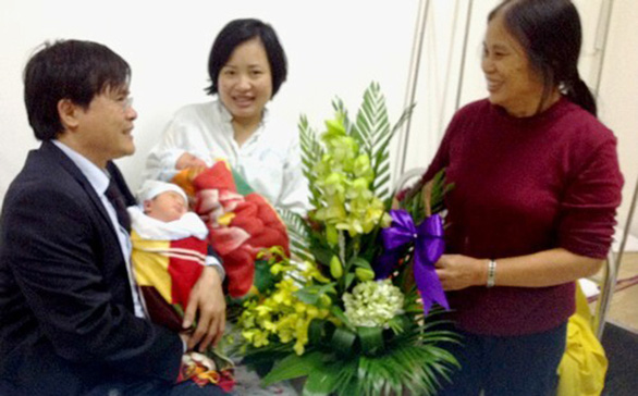 Dr. Le Luong Van Ve and his wife visited Hoang Thi Kim Dung (center) after she gave birth to her twin boys from her dead husband’s frozen sperm in 2013. Dr. Ve, who successfully performed the miracle procedure, and his wife also act as the newborns’ godparents. Photo: Tuoi Tre