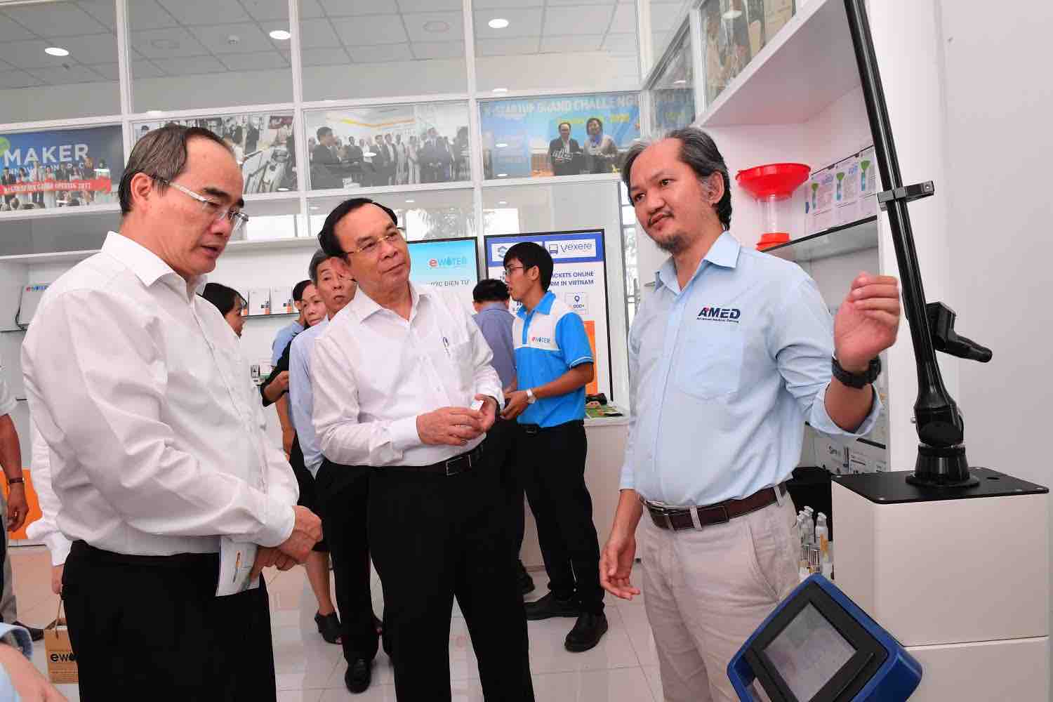 Luong Vu Dang Quang presents laser devices to Nguyen Van Nen, secretary of the Ho Chi Minh City Party Committee, at a startup product launching event in Ho Chi Minh City. Photo: T. Trung / Tuoi Tre