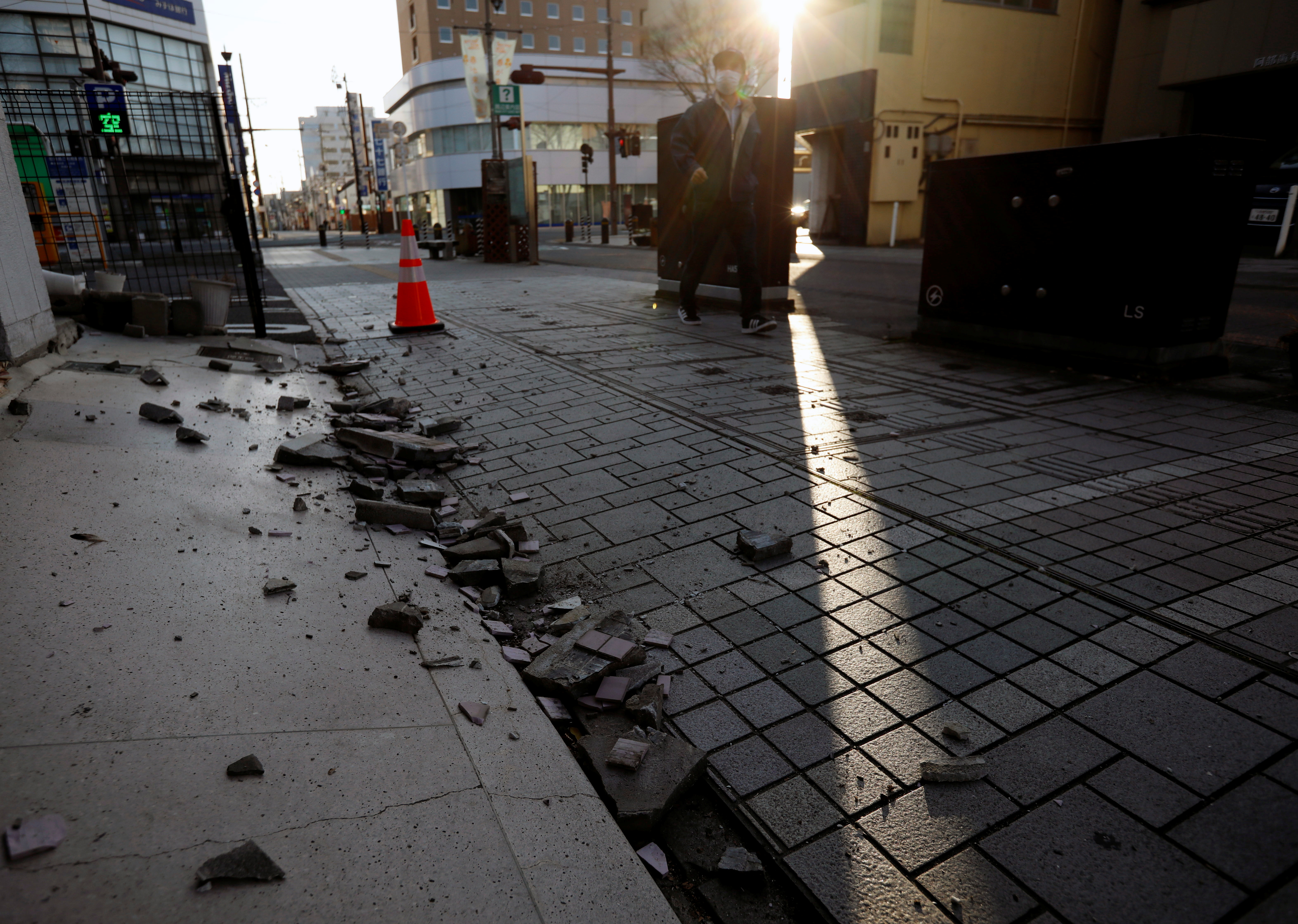 Collapsed exterior wall of a building caused by a strong earthquake are seen on the street in Iwaki, Fukushima prefecture, Japan February 14, 2021. Photo: Reuters