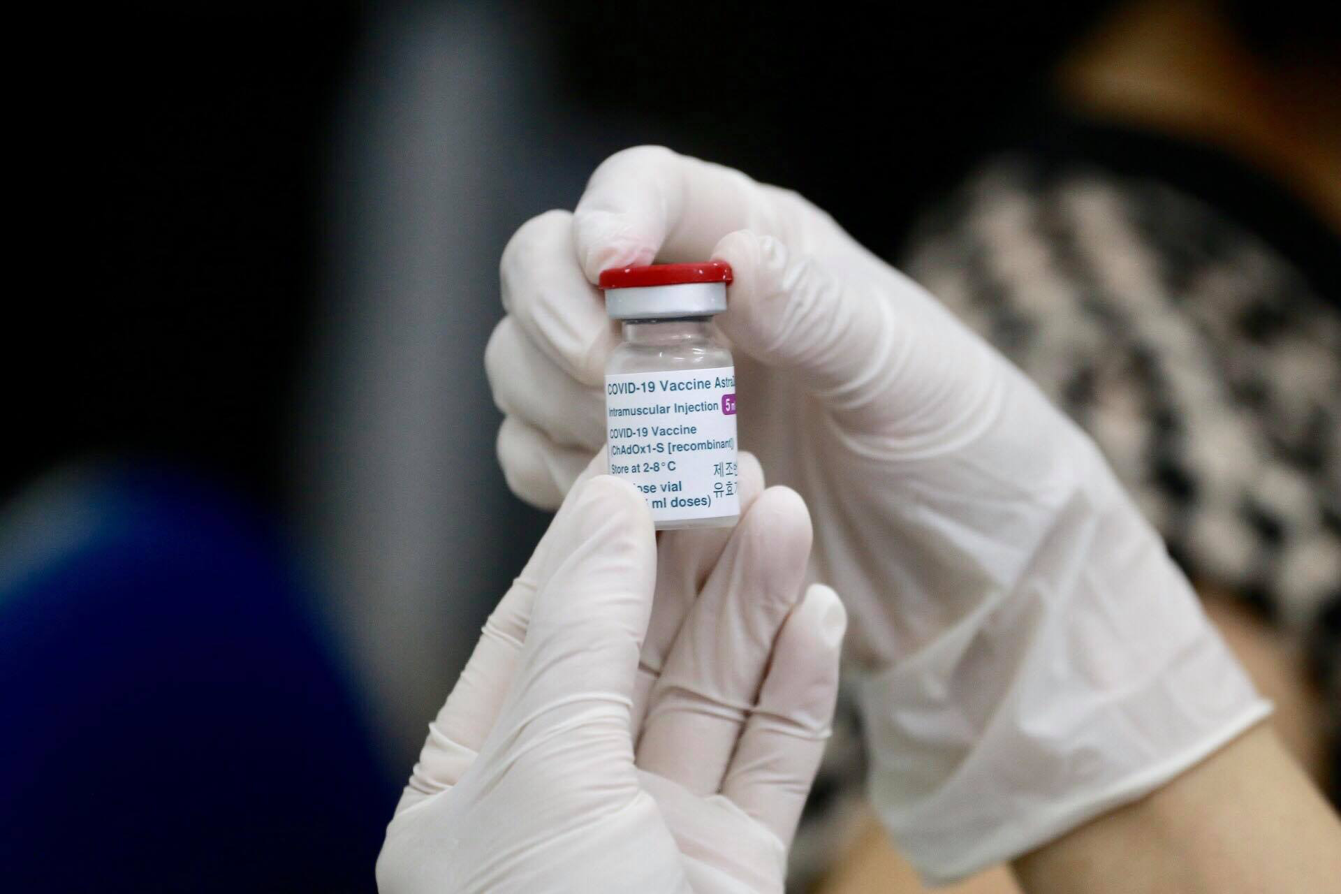 A health worker holds a bottle of COVID-19 vaccine developed by AstraZeneca and Oxford University in Hai Duong Province, Vietnam, March 8, 2021. Photo: Chi Tue / Tuoi Tre