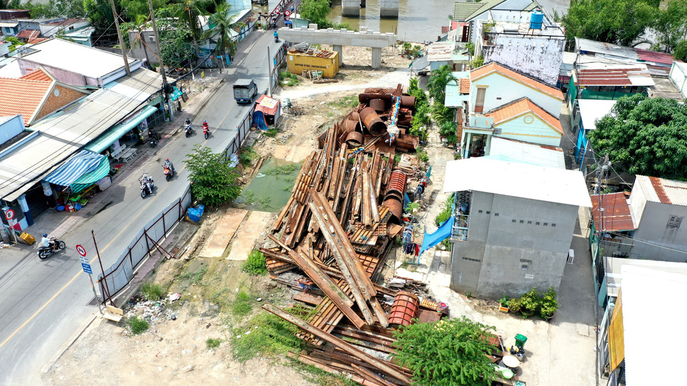 Rusty steel beams and cylinders lie across the fronts of houses along Le Van Luong Street years in Nha Be District, Ho Chi Minh City. Photo: Tu Trung / Tuoi Tre