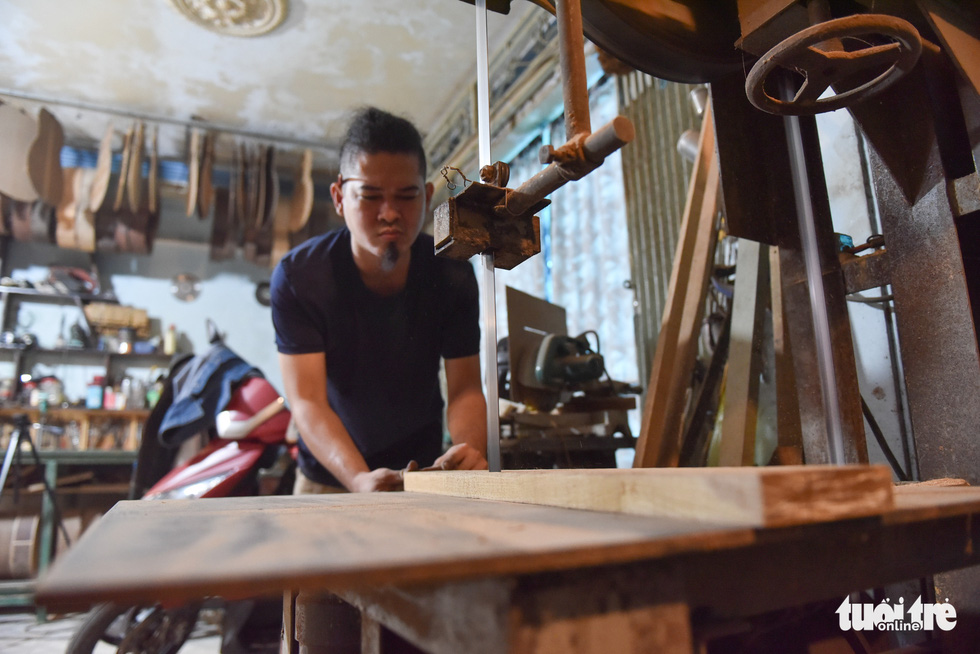 Thang handles a piece of wood in his workshop. Photo: Ngoc Phuong/Tuoi Tre.